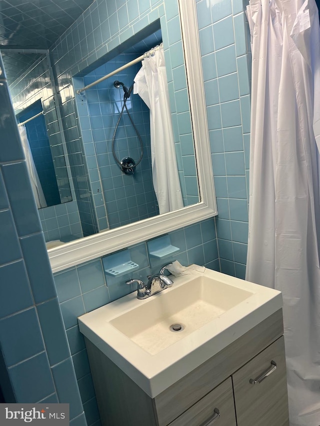 bathroom featuring vanity, backsplash, tile walls, and walk in shower