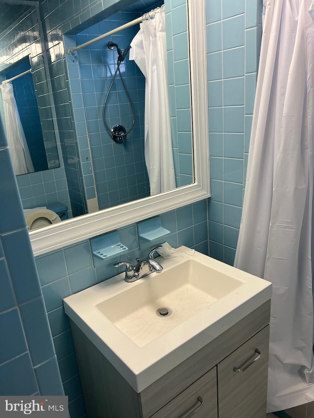 bathroom featuring sink, tile walls, and tasteful backsplash