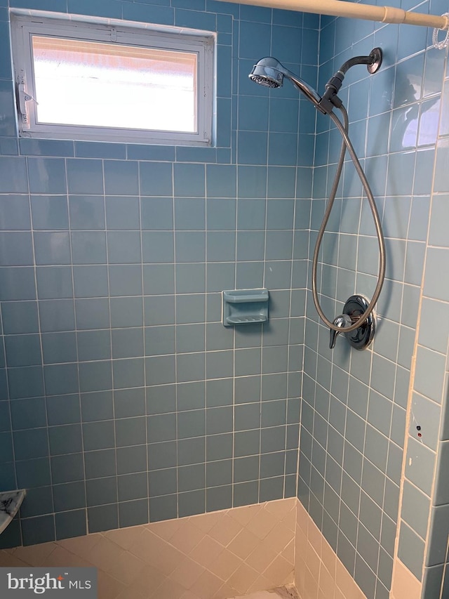 bathroom featuring tiled shower and plenty of natural light