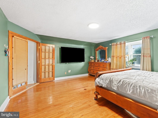 bedroom with a textured ceiling and hardwood / wood-style flooring