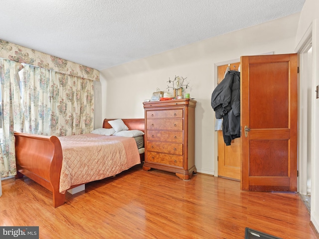 bedroom featuring light wood-type flooring and a textured ceiling