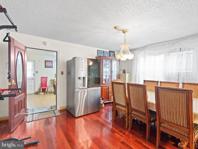 dining room featuring dark hardwood / wood-style flooring, an inviting chandelier, and plenty of natural light