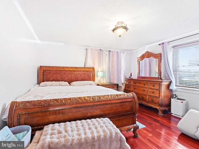 bedroom with a textured ceiling and hardwood / wood-style flooring