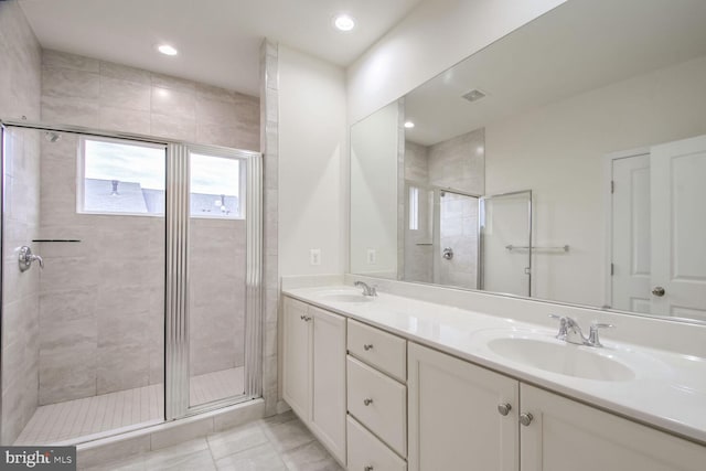 bathroom with a shower with door and vanity