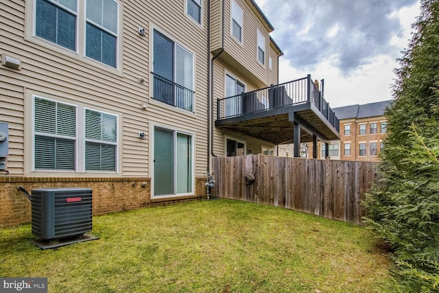 back of property featuring a lawn and central air condition unit