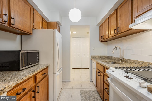 kitchen with white stove, sink, decorative backsplash, light tile patterned floors, and decorative light fixtures