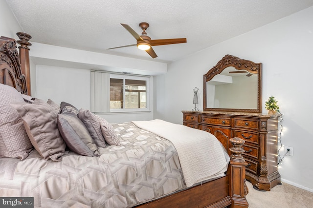 bedroom with ceiling fan, light colored carpet, and a textured ceiling