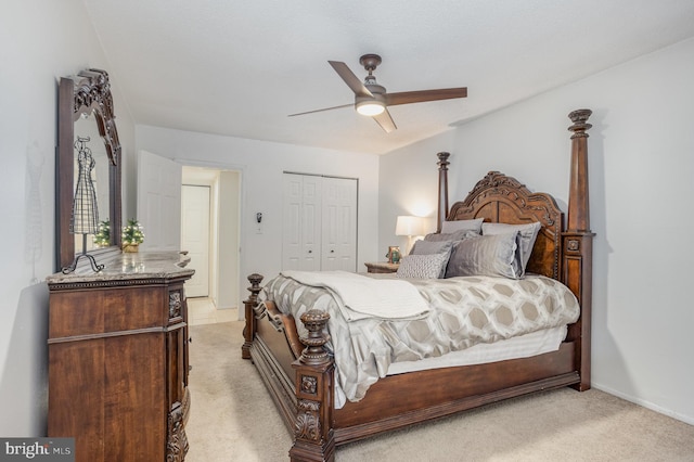 bedroom with ceiling fan, light carpet, and a closet