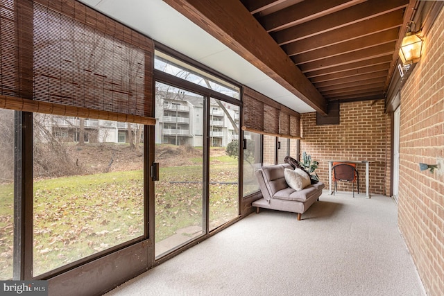 unfurnished sunroom featuring plenty of natural light and beam ceiling