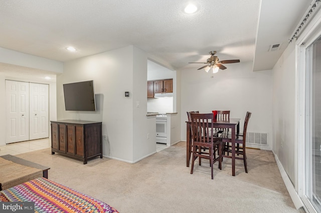 carpeted dining space featuring ceiling fan