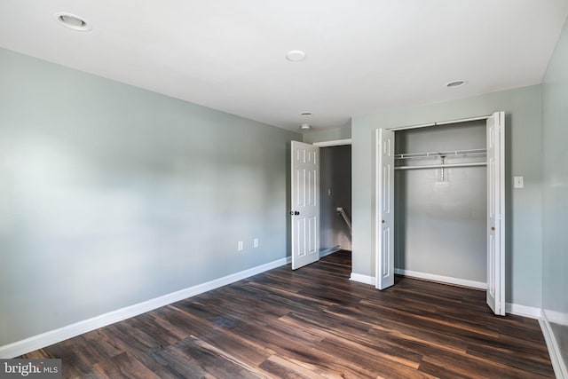 unfurnished bedroom featuring dark hardwood / wood-style flooring and a closet