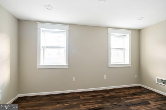 unfurnished room with a wealth of natural light and dark hardwood / wood-style floors