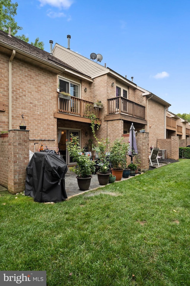 rear view of property with a lawn and a balcony