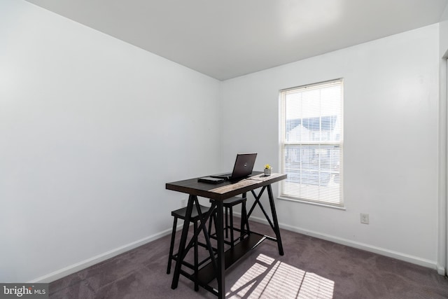 office area with a wealth of natural light and dark colored carpet