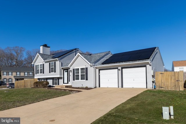 view of front of house with solar panels, a front lawn, and a garage