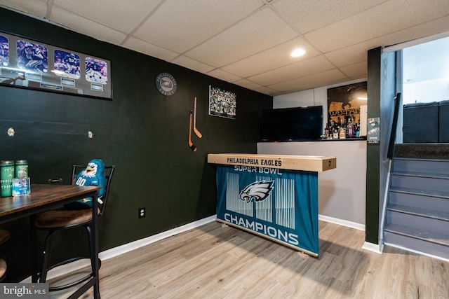 bar featuring a drop ceiling and hardwood / wood-style flooring