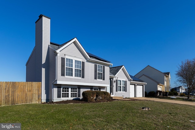 view of front of home with solar panels, a garage, and a front yard