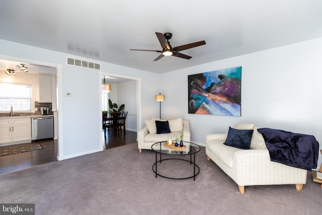 living room featuring sink, dark carpet, and ceiling fan