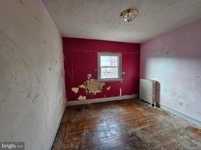 empty room with a textured ceiling and radiator