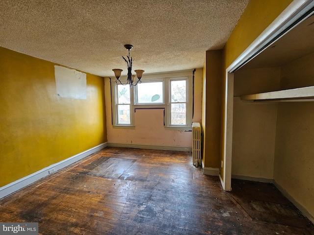 unfurnished dining area featuring a notable chandelier, a textured ceiling, and radiator