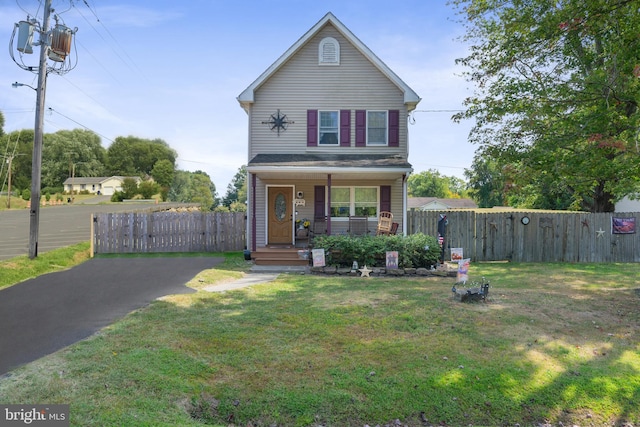 front facade with covered porch and a front yard