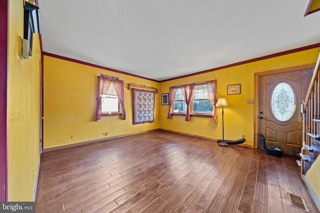 foyer with hardwood / wood-style flooring, a healthy amount of sunlight, and ornamental molding