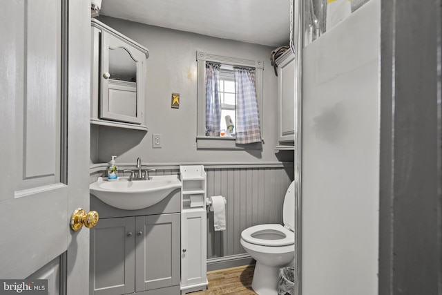 bathroom with hardwood / wood-style floors, vanity, and toilet