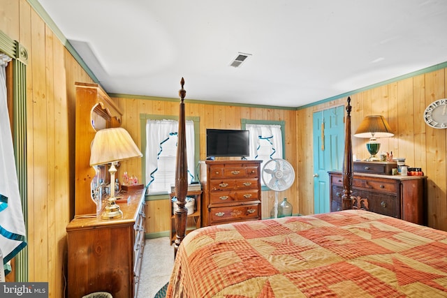 bedroom featuring wooden walls and light colored carpet