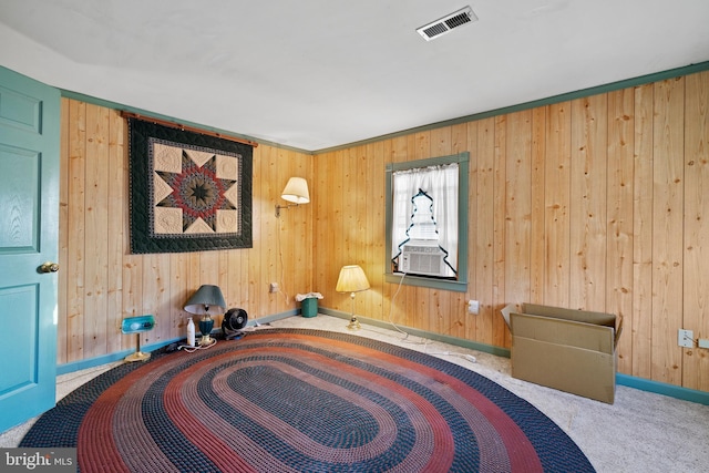 sitting room featuring wood walls, carpet floors, crown molding, and cooling unit