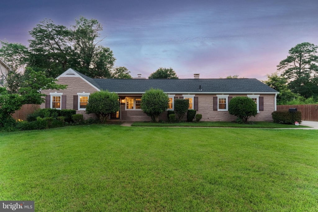 ranch-style home with a yard