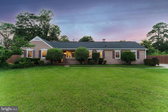 ranch-style home with a yard