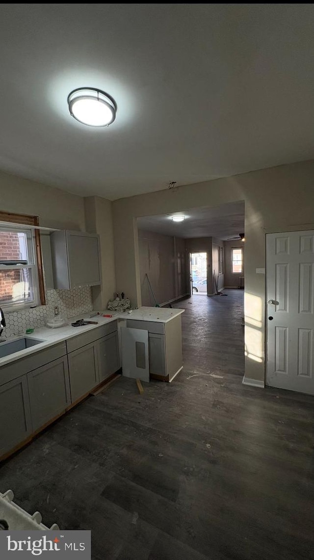 kitchen featuring sink, tasteful backsplash, gray cabinets, and kitchen peninsula