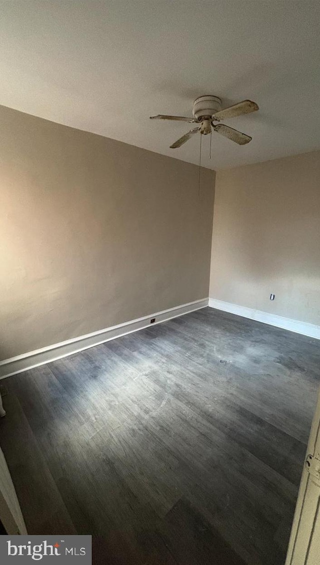 spare room featuring dark hardwood / wood-style flooring and ceiling fan