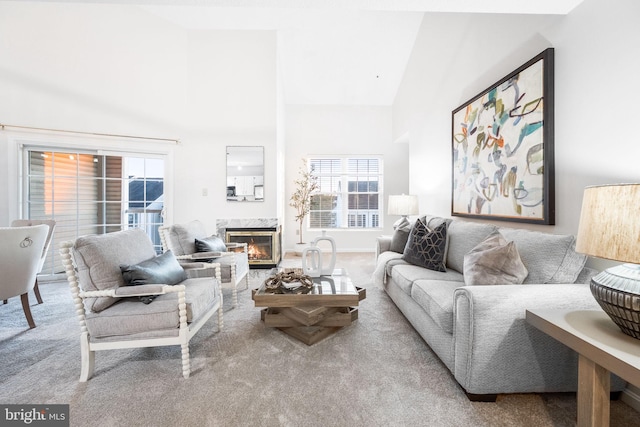 living room with light colored carpet, a fireplace, and high vaulted ceiling