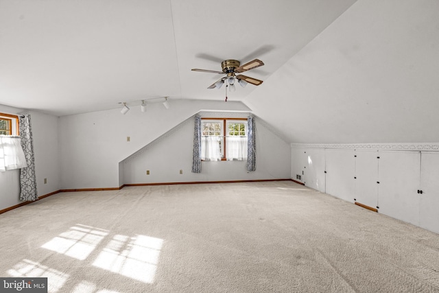 additional living space featuring ceiling fan, light colored carpet, and lofted ceiling