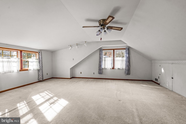 additional living space featuring light carpet, vaulted ceiling, and ceiling fan