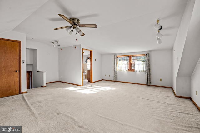 interior space featuring ceiling fan, light colored carpet, and vaulted ceiling