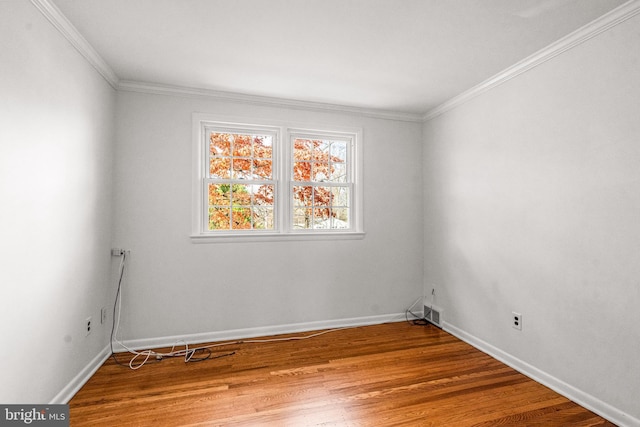 empty room featuring hardwood / wood-style floors and ornamental molding