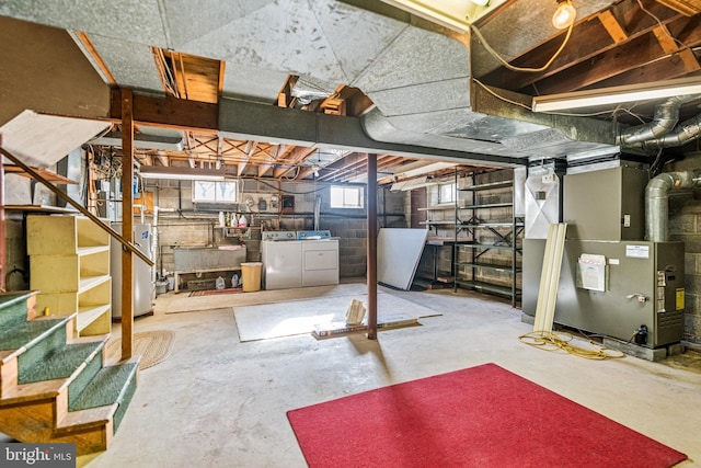 basement with separate washer and dryer, water heater, heating unit, and sink