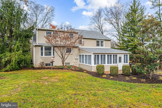 back of house with a lawn and a sunroom