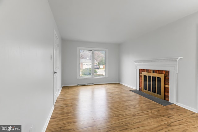 unfurnished living room featuring a fireplace and light hardwood / wood-style flooring