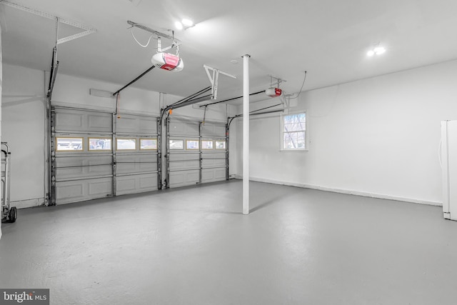 garage featuring white refrigerator and a garage door opener