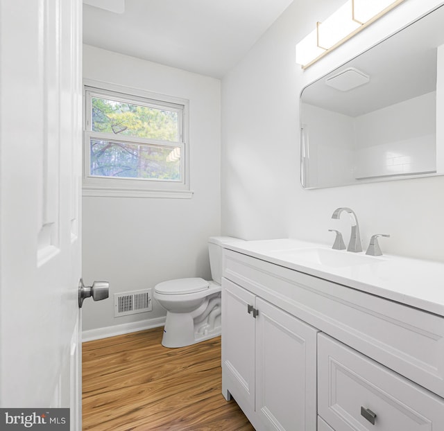 bathroom with hardwood / wood-style floors, vanity, and toilet