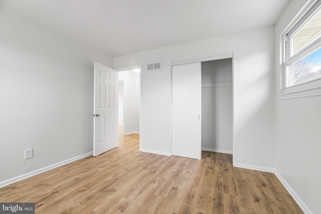 unfurnished bedroom featuring a closet and light hardwood / wood-style floors