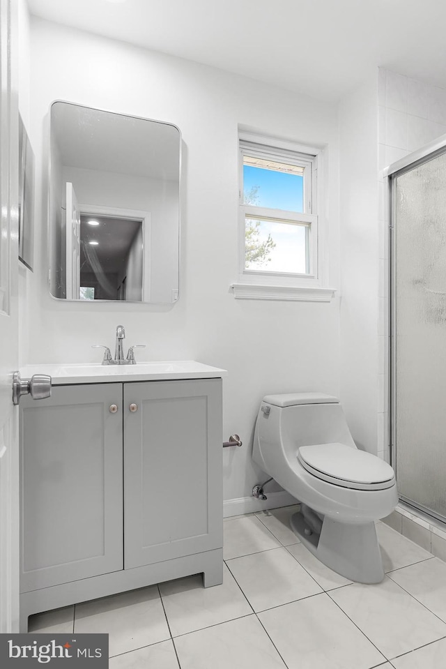 bathroom with tile patterned flooring, vanity, toilet, and walk in shower