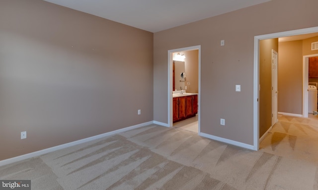 unfurnished bedroom featuring sink, connected bathroom, and light carpet