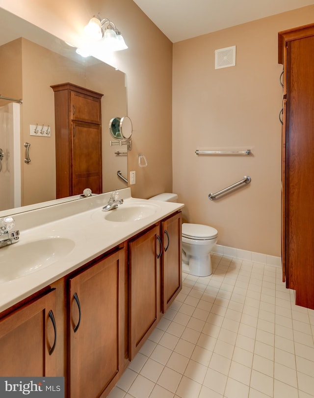 bathroom with vanity, tile patterned flooring, and toilet