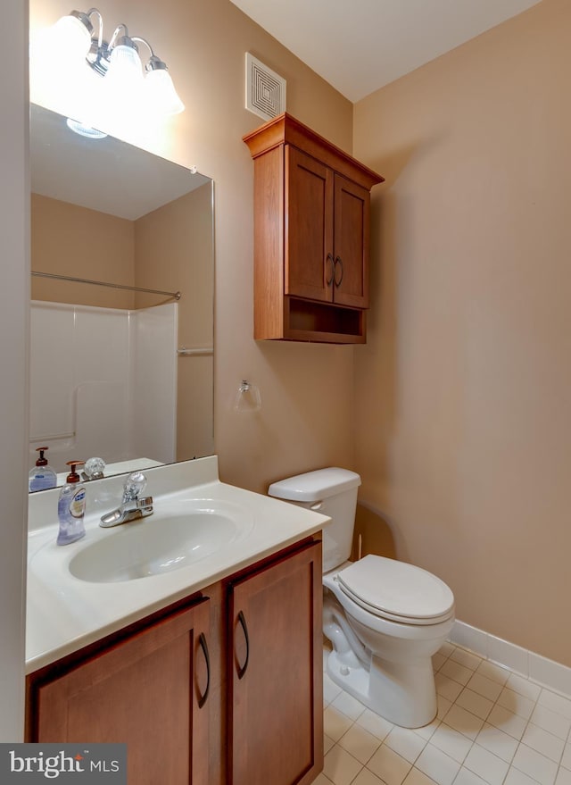 bathroom featuring vanity, a shower, tile patterned flooring, and toilet