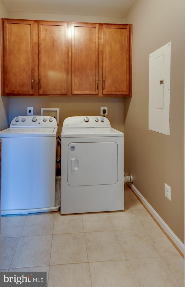 washroom with electric panel, washer and dryer, cabinets, and light tile patterned floors