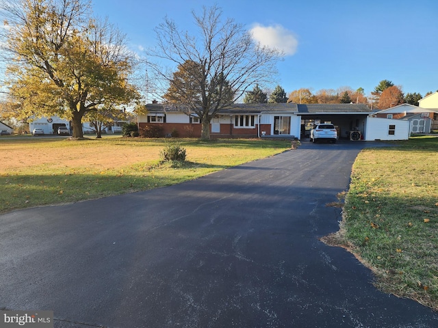 ranch-style house featuring a carport and a front yard